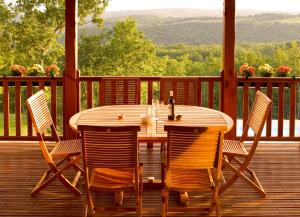 einen Holztisch und Stühle auf einer Holzterrasse in der Unterkunft Résidence Souillac Golf & Country Club in Lachapelle-Auzac