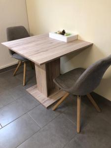 une table en bois avec deux chaises et une boîte au-dessus dans l'établissement Gemütliches Apartment nahe Porsche, à Weissach