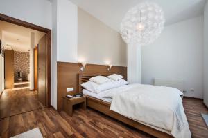 ein Schlafzimmer mit einem großen Bett und einem Kronleuchter in der Unterkunft Family Apartment, Apartment House Oliver in Štrbské Pleso