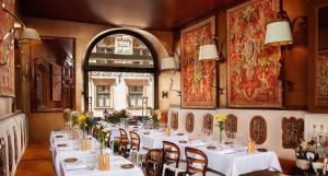 a restaurant with white tables and chairs and a window at Kanonicza 22 in Krakow