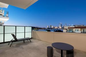 a chair and a table on a balcony with a view at Quest South Perth Foreshore in Perth