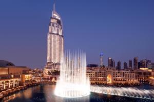 um edifício alto com uma fonte em frente a uma cidade em Address Downtown no Dubai