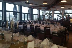 a dining room with white tables and chairs and windows at Altes Ruderhaus in Worms