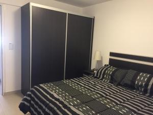 Schlafzimmer mit einem Bett mit einem großen schwarzen Kopfteil in der Unterkunft Apartamentos del Sol in San Carlos de Bariloche