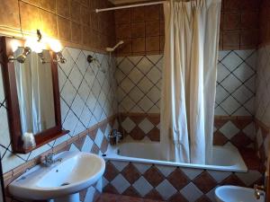 ein Badezimmer mit einer Badewanne, einem Waschbecken und einem Spiegel in der Unterkunft Hostal Nicol's in Luque