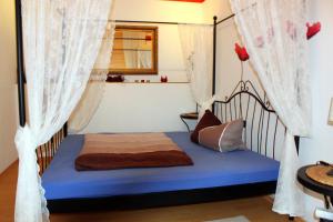 a bedroom with a bed with curtains and a blue mattress at Ferienwohnung "Zur Alten Schule" Neuburxdorf in Neuburxdorf