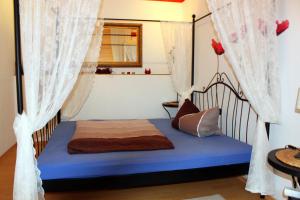 a bedroom with a bed with curtains and a blue mattress at Wellness-Suiten Neuburxdorf in Neuburxdorf