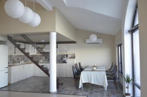 a dining room with a table and a kitchen at Ashram Hotel in Primorsko