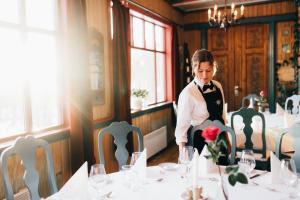 uma mulher de pé numa mesa num restaurante em Tuddal Høyfjellshotel em Tuddal