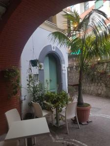 a patio with a table and chairs and a green door at Casa Lulù in Minori