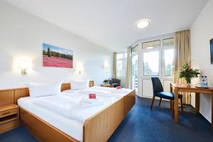 a hotel room with a bed and a desk at Krelinger Freizeit- und Tagungszentrum in Walsrode