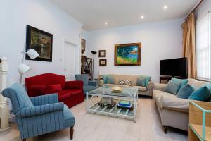 a living room with couches and a tv at Veeve - A Kensington Mews in London