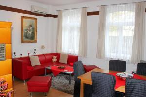 a living room with a red couch and a table at Ferienwohnung "Zur Alten Schule" Neuburxdorf in Neuburxdorf