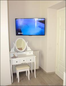 toaletka z lustrem i telewizor na ścianie w obiekcie Big Central Room w mieście La Spezia