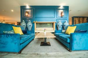 a blue living room with two blue couches and a table at De Vere Cotswold Water Park in Cirencester