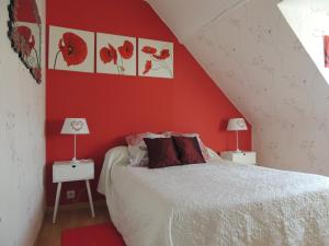 Saint-Jouin-BrunevalにあるFleur De Soleilの赤い壁のベッドルーム1室(ベッド1台、ランプ2つ付)