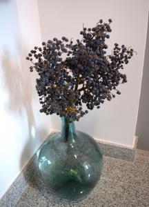 zielona waza z kwiatami na stole w obiekcie Hotel Mica w mieście Palas de Rei 