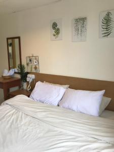 a bed with white sheets and pillows in a bedroom at coralbay apartment pangkor island in Pangkor