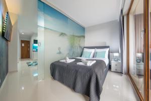 ein Schlafzimmer mit einem Bett und einer Glaswand in der Unterkunft Resorts Kołobrzeg, Sun & Snow in Kołobrzeg