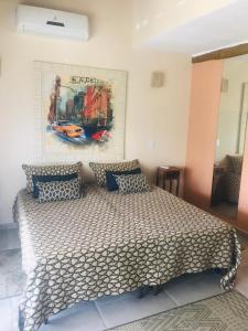 a bedroom with a bed with a poster on the wall at Duplex Ilhabela Pereque in Ilhabela