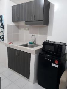 a kitchen with a sink and a microwave at HappyNest Couple room DF in Tagaytay