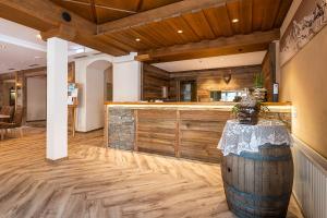 Großes Zimmer mit einer Bar mit Holzwänden in der Unterkunft SCOL Sporthotel Zillertal in Fügen