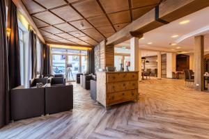 a lobby with couches and a counter in a building at SCOL Sporthotel Zillertal in Fügen