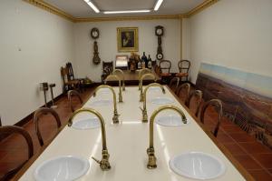 Baño con 4 lavabos en una habitación con sillas en Hotel Torremilanos, en Aranda de Duero