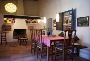 a dining room with a table and chairs and a fireplace at Can Pep Antonina in San Ferrán de ses Roques