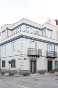 a white building with two balconies on a street at Matilde in Isola delle Femmine