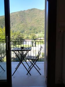 a table and chairs on a balcony with a view of a mountain at Casa Felicité - di Francesca e Antonio in Valmareno