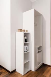 a white refrigerator next to a white wall at Alea Home Roma in Rome