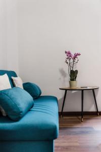 a blue couch in a living room with a table at Alea Home Roma in Rome