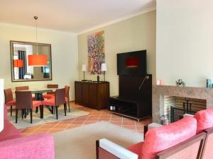 a living room with a fireplace and a dining room at Casa de Férias Vila Sol Golf in Quarteira