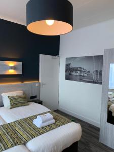 een slaapkamer met een bed met een zwarte muur bij Hotel & Appartementen Royal in Sas van Gent