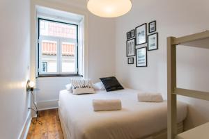 a white bedroom with a bed and a window at JOIVY Splendid 2BR flat in Bairro Alto, nearby Luís de Camões Square in Lisbon