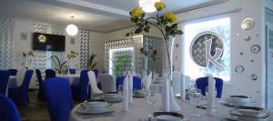a dining room with a table with blue chairs at Casa OK by OVO in Vama Veche