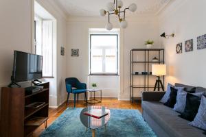 a living room with a couch and a tv at JOIVY Splendid 2BR flat in Bairro Alto, nearby Luís de Camões Square in Lisbon