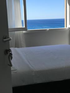 a white bed sitting in front of a window at Gioia Bed and Breakfast in Finale Ligure