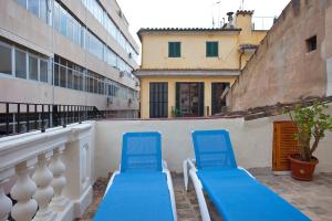 2 sillas azules sentadas en el balcón de un edificio en Turismo de Interior Ca Sa Padrina en Palma de Mallorca