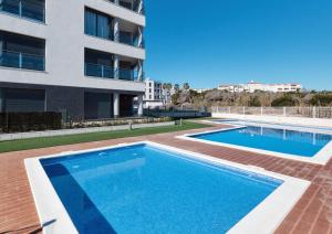 a swimming pool in front of a building at Sunny Sea in La Mata