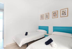 two beds in a room with white and blue at Sunny Sea in La Mata +44 photos