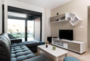 ein Wohnzimmer mit einem Sofa und einem TV in der Unterkunft Sunny Sea in La Mata