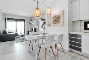 a kitchen and dining room with a white table and chairs at Sunny Sea in La Mata