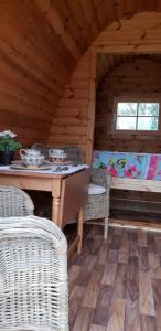 ein Esszimmer mit einem Tisch und Korbstühlen in einer Hütte in der Unterkunft Glamping at Treegrove in Kilkenny