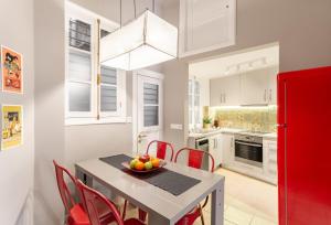 a kitchen with a table with red chairs and a red refrigerator at Hidesign Athens Apollon Luxury Apt in Plaka Acropolis in Athens