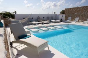 a pool with lounge chairs and a swimming pool at Hotel Macondo in Lampedusa
