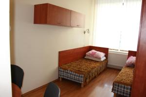 um pequeno quarto com uma cama e uma janela em Ignalinos sporto ir pramogų centras em Ignalina