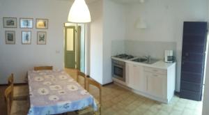una cucina con tavolo, lavandino e piano cottura di Casa della Nonna a Gargnano