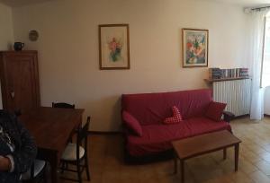 un soggiorno con divano rosso e tavolo di Casa della Nonna a Gargnano
